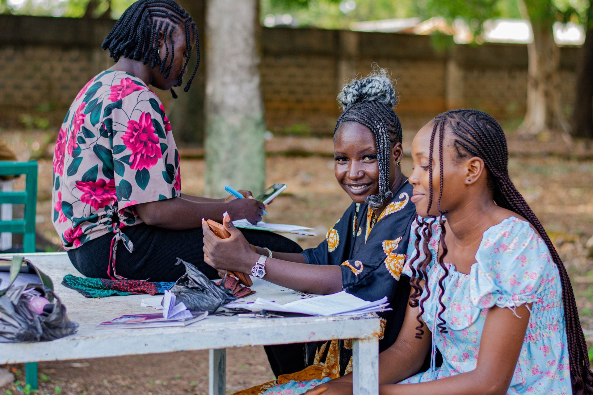 Etudiantes Africaines souriantes, assises dans la cour.